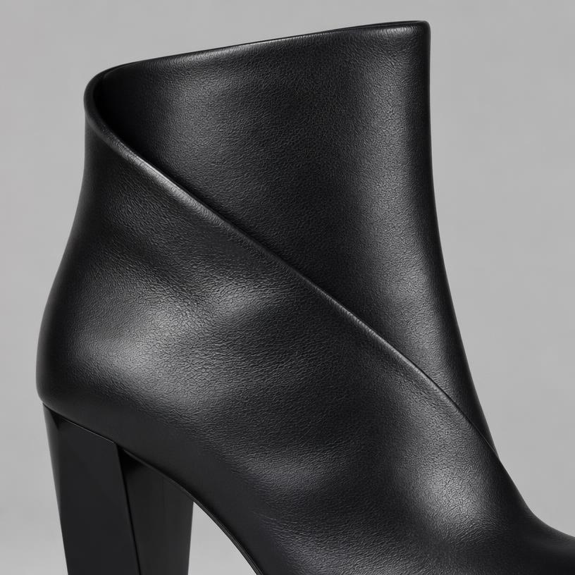Close crop of a sculptural black leather ankle boot